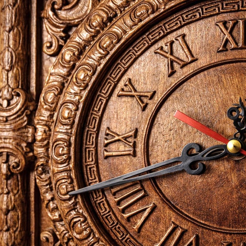 May include: Close-up of a wooden clock with Roman numerals. The clock face is a warm brown color, with ornate carvings around the edge. The hands are black, with a red second hand and a gold center.