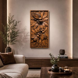 May include: A rectangular wooden wall relief depicting three bees and a flower, carved in detail. The artwork has a warm brown hue, with textured surfaces and shadows. The piece is mounted on a neutral wall, offering a nature-inspired decorative element. The dimensions are in centimeters.