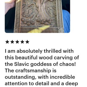 May include: A detailed wood carving depicting a Slavic goddess, framed in a rectangular border. The artwork features intricate relief carvings of figures and natural elements, showcasing fine craftsmanship.