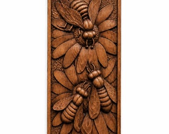 May include: A rectangular wooden relief carving depicting three bees on a flower. The bees are intricately carved with detailed wings and bodies. The flower has multiple petals. The artwork is framed in a dark wood.