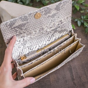Interior of genuine python wallet showing multiply bill compartments and a zippered pocket