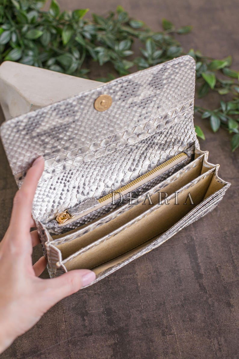 Interior of genuine python wallet showing multiply bill compartments and a zippered pocket