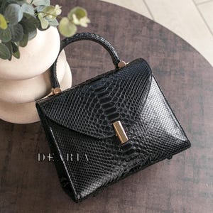 Luxury black glossy python leather handbag with gold hardware