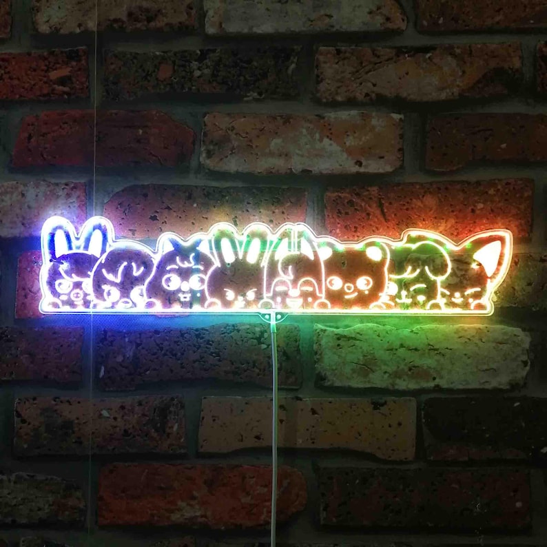 May include: A neon sign featuring a row of cartoon animal faces, including a bunny, bear, and dog, against a brick wall. The sign glows with a rainbow of colors, including blue, green, and orange. The sign is a decorative item.