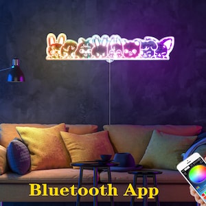 May include: A colorful LED light fixture shaped like a row of cartoon animals. The light is mounted on a wall above a sofa. The words "Bluetooth App" are displayed in yellow text at the bottom of the image. A smartphone displays a color wheel.