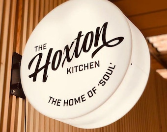Puede incluir: Señal blanca iluminada con texto negro que dice "The Hoxton Kitchen, The Home of 'Soul'".