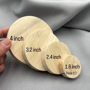 May include: Four wooden circles of varying sizes, stacked and displayed. The largest is 4 inches in diameter, followed by 3.2, 2.4, and 1.6 inches. The smallest is 0.7 inches thick. The wood has a light, natural color.