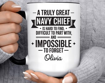 May include: White ceramic mug with a black handle and rim. The mug features the text "A Truly Great Navy Chief" with additional text below, including a name. A perfect gift for a Navy Chief.