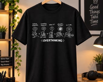 May include: A black short-sleeved t-shirt featuring a white graphic print of a stick figure's thought process. The design includes the text "Nothing happened...", "Something happened...", "What if?", "Why did I say that?", "It's 3 AM...", and "OVERTHINKING".