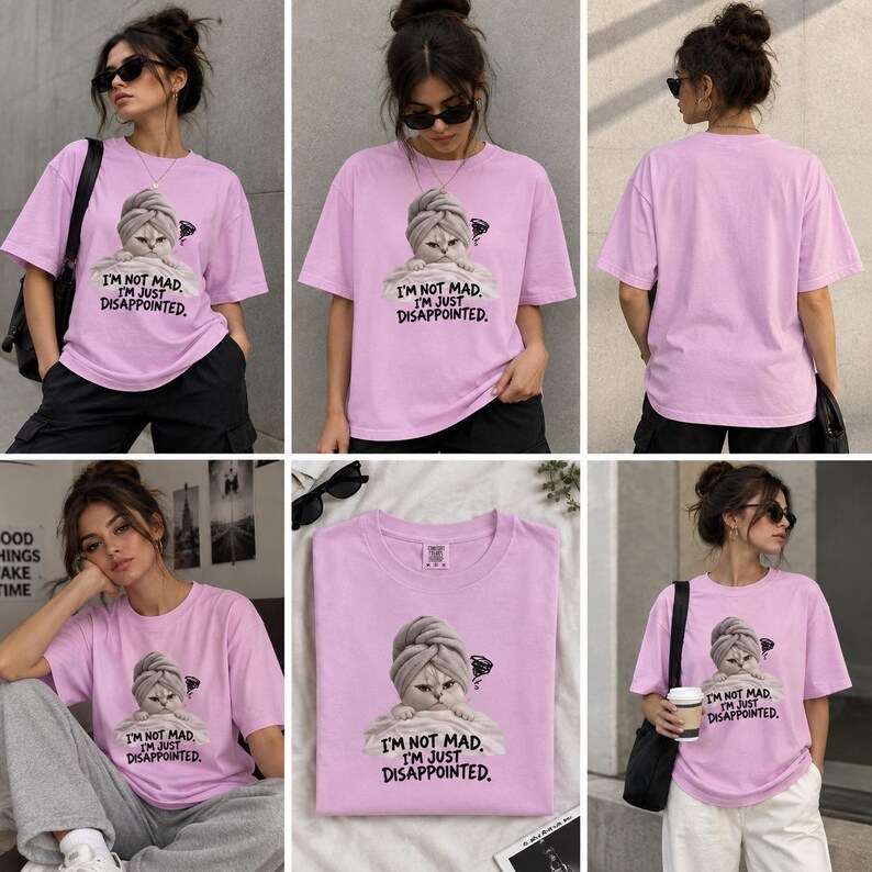 May include: A light purple short-sleeve t-shirt featuring a graphic of a cat wearing a towel on its head with the text "I'M NOT MAD. I'M JUST DISAPPOINTED." The shirt has a crew neckline and a relaxed fit, shown from both front and back views.