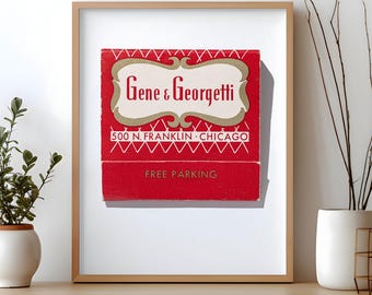 May include: A framed print featuring a vintage red matchbook cover with the text Gene & Georgetti, 500 N. FRANKLIN CHICAGO, and FREE PARKING. The design includes a cream-coloured decorative border and white geometric line patterns on a red background.