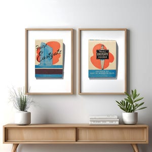 May include: Two framed prints of vintage matchbook covers for the Hotel Eastgate in Chicago. The left print features a blue and orange illustration of the hotel building. The right print features a woman holding a sign that says "Hotel Eastgate Chicago".