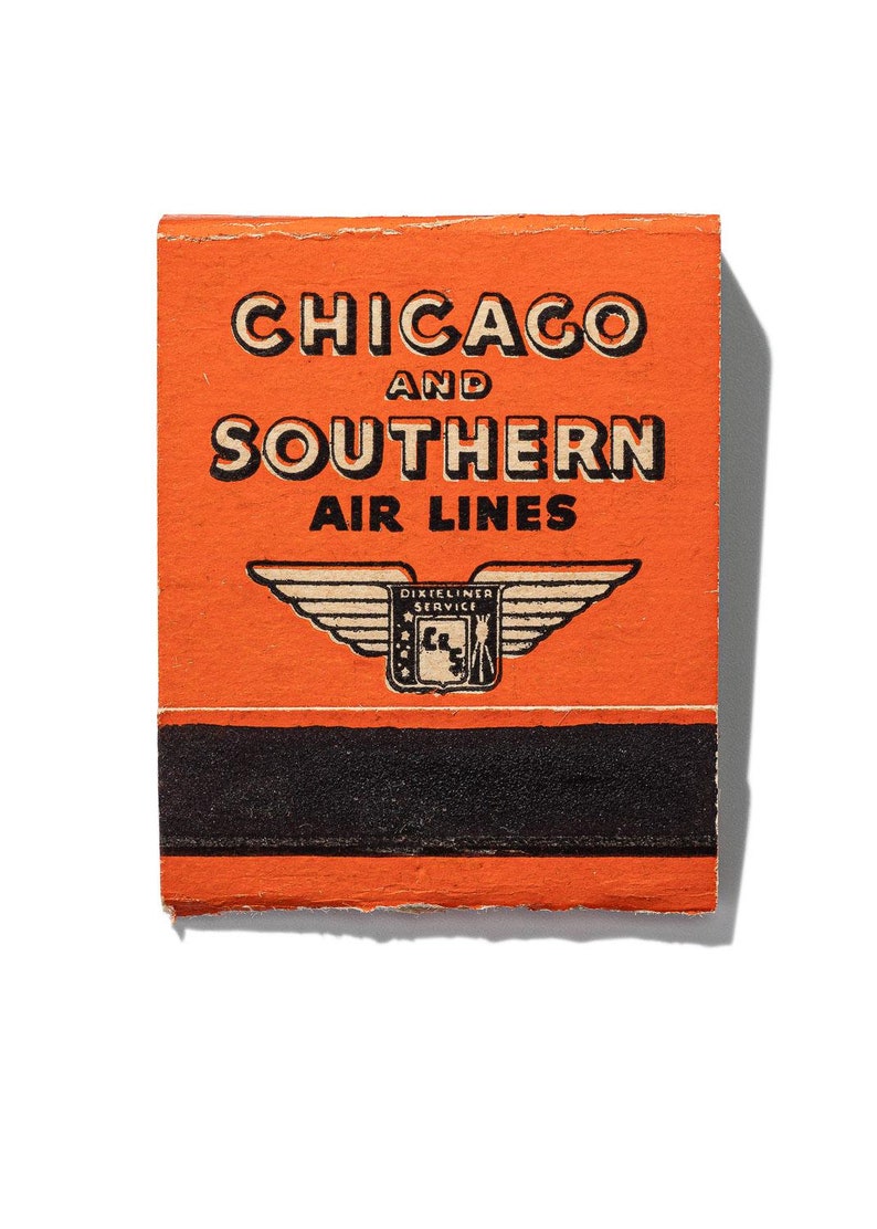May include: An orange matchbook cover with black text that reads "Chicago and Southern Air Lines" and a black and white logo of a winged shield with the text "Dixie Liner Service".