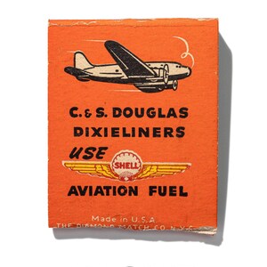 May include: Orange matchbox with a black and white illustration of a plane and the text "C. & S. DOUGLAS DIXIELINERS USE SHELL AVIATION FUEL Made in U.S.A. THE DIAMOND MATCH CO. N.Y.C."