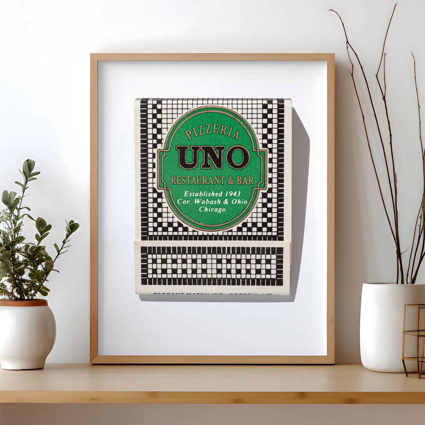 May include: A framed print featuring a vintage matchbook cover for Pizzeria Uno Restaurant & Bar. The design includes a green oval with black text reading Pizzeria Uno Restaurant & Bar, Established 1943, Cor. Wabash & Ohio, Chicago, on a black and white checkered background.