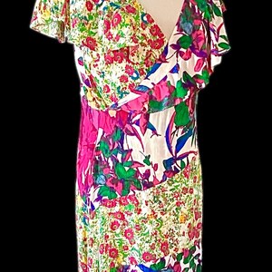 May include: A floral print dress with a V-neckline and flutter sleeves. The dress features a mix of pink, green, and blue floral patterns on a white background. The dress is displayed on a mannequin.