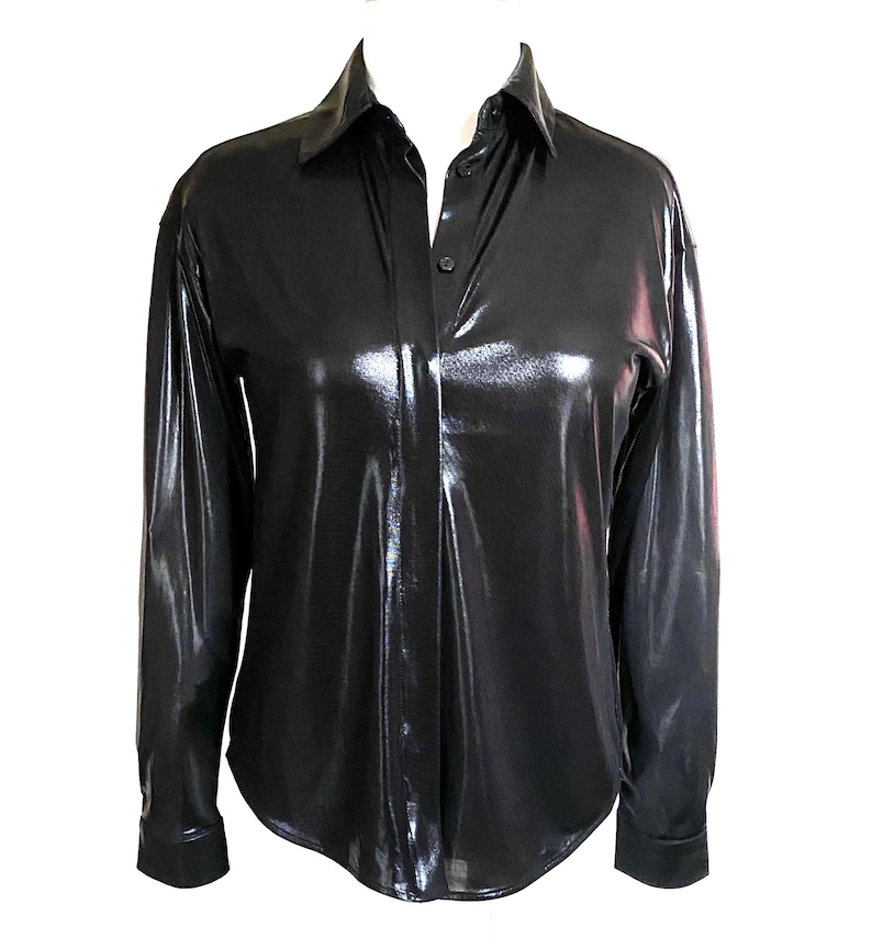 May include: A black long-sleeved shirt with a shiny, metallic finish. The shirt has a button-up collar and a button closure.