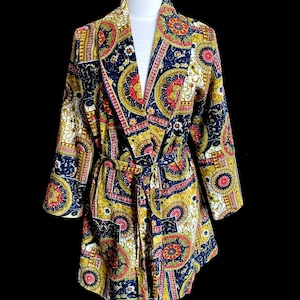 May include: A long-sleeved robe with a paisley print in shades of blue, gold, red, and white. The robe has a shawl collar and a tie belt.