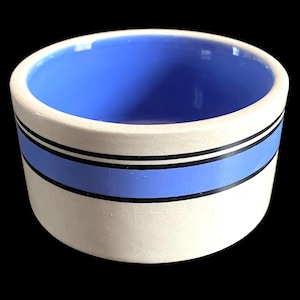 May include: A white ceramic mug with a black handle and the text "But First, Coffee" in a handwritten style. The mug is on a white surface. The mug is 4 inches tall.