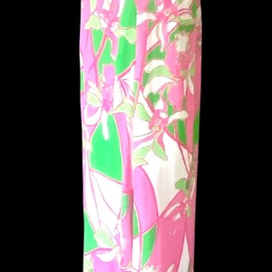 Op de afbeelding: Een lange halterjurk met een bloemenpatroon in roze, groen en wit. De jurk heeft een getailleerd lijfje en een zwierige rok. Perfect voor een zomerse gelegenheid.