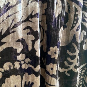 Puede incluir: Primer plano de una tela con un patr&oacute;n floral en tonos marrones, beige y morado. La tela tiene una textura suave y aterciopelada.