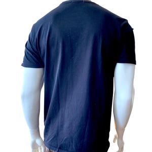 May include: A navy blue t-shirt with short sleeves. The shirt is displayed on a mannequin against a white background. The shirt is made of a soft, comfortable material.