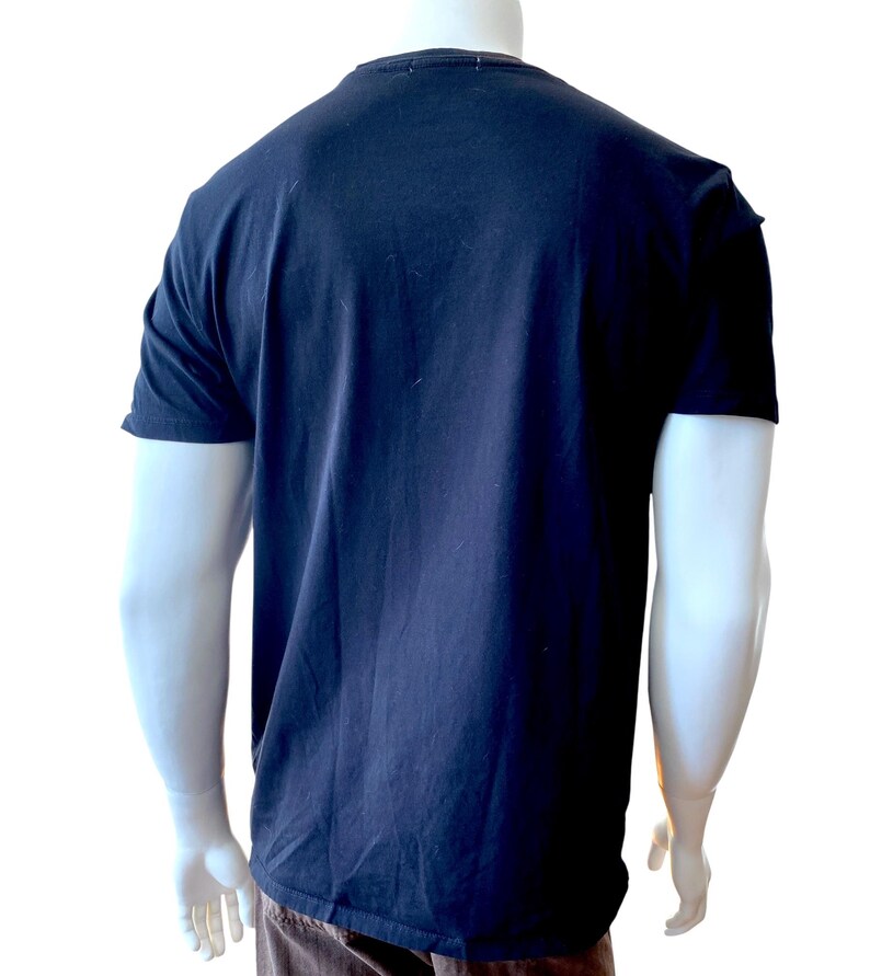 May include: A navy blue t-shirt with short sleeves. The shirt is displayed on a mannequin against a white background. The shirt is made of a soft, comfortable material.
