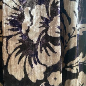 Puede incluir: Primer plano de una tela con un patr&oacute;n floral. La tela es de color marr&oacute;n oscuro con un dise&ntilde;o floral marr&oacute;n claro. Las flores son grandes y tienen una textura ligeramente en relieve.