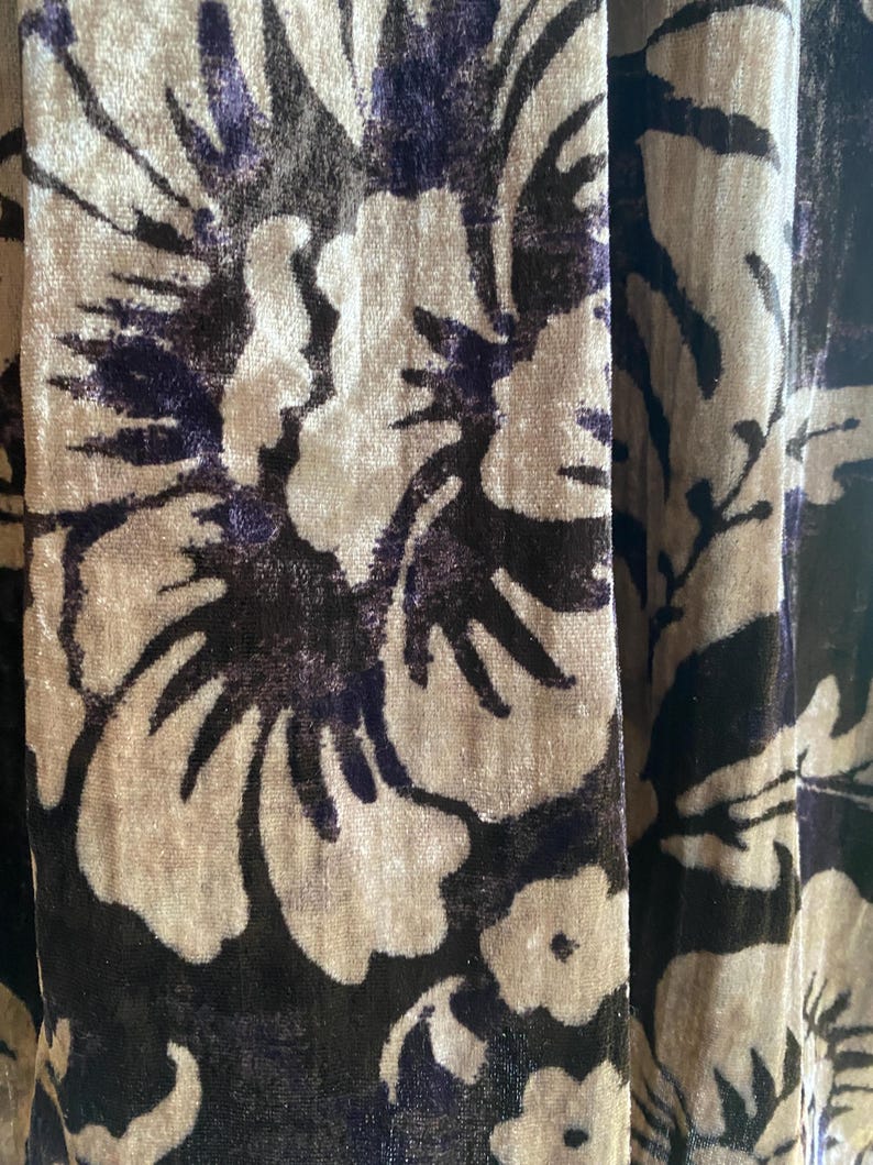 Puede incluir: Primer plano de una tela con un patr&oacute;n floral. La tela es de color marr&oacute;n oscuro con un dise&ntilde;o floral marr&oacute;n claro. Las flores son grandes y tienen una textura ligeramente en relieve.
