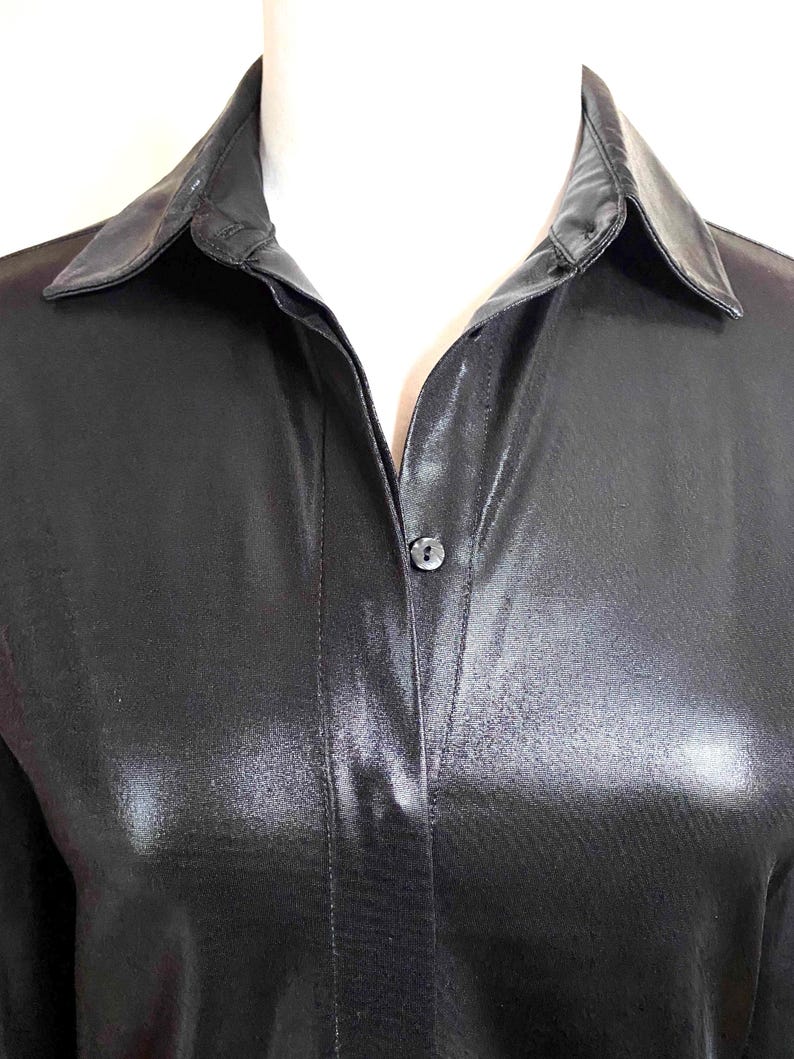 May include: A black satin shirt with a button-up closure and a classic collar.