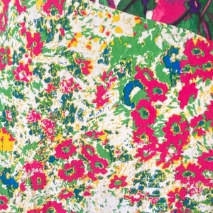 May include: Close-up of a fabric with a floral pattern. The design features a mix of pink, green, blue, and yellow flowers and foliage on a white background. The fabric has a vintage, hand-painted aesthetic.