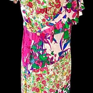 May include: A colorful floral print dress with a V-neckline and flutter sleeves. The dress features a mix of pink, green, blue, and white floral patterns. The dress is a vibrant and eye-catching piece.