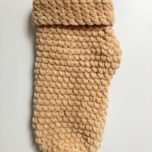 Pu&ograve; includere: Un maglione di lana beige per cani con collo alto.