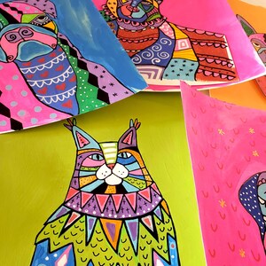 Peut inclure: Une peinture abstraite color&eacute;e d'un chat avec un motif bleu, vert et violet. Le chat est assis sur un fond vert.