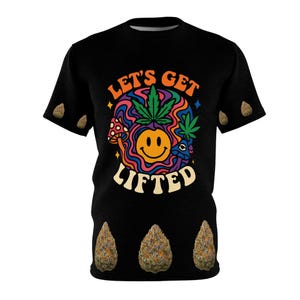 May include: Black t-shirt with a colorful graphic that says "Let's Get Lifted." The design includes a smiling face, cannabis leaves, and mushrooms. The shirt also features three cannabis buds at the bottom and three on the sleeves.