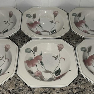 May include: Set of six octagonal white ceramic bowls. Each bowl features a floral design with pink and gray flowers, green leaves, and a gray stem. The bowls have a thin, silver-colored trim.