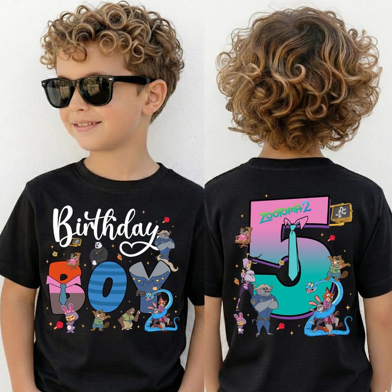 A young boy wearing a black t-shirt with a colorful graphic design and text on the front and back.