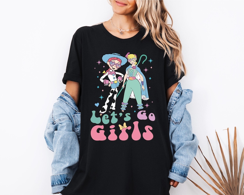 a woman wearing a black t - shirt with a cartoon character on it