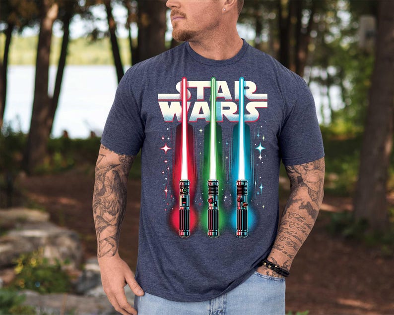 a man wearing a star wars t - shirt with lightsabes on it