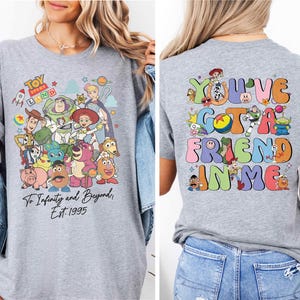 a woman wearing a grey tshirt with cartoon characters on it