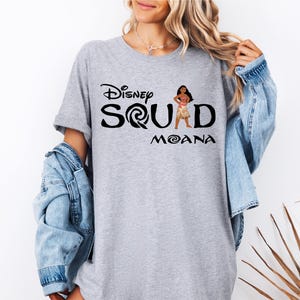 a woman wearing a disney shirt with the word squad moan on it