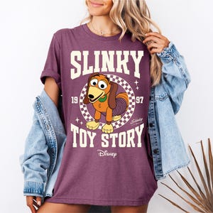 a woman wearing a shirt that says slinky is a toy story