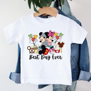 a white shirt with mickey mouse and minnie mouse on it