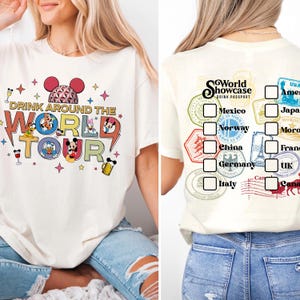 May include: An off-white t-shirt featuring a front graphic with the text Drink Around The World Tour, cartoon characters, and a geodesic dome icon. The back graphic displays a World Showcase Drink Passport list with country names and checkboxes.