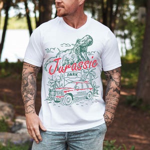 a man wearing a white t - shirt with a dinosaur on it