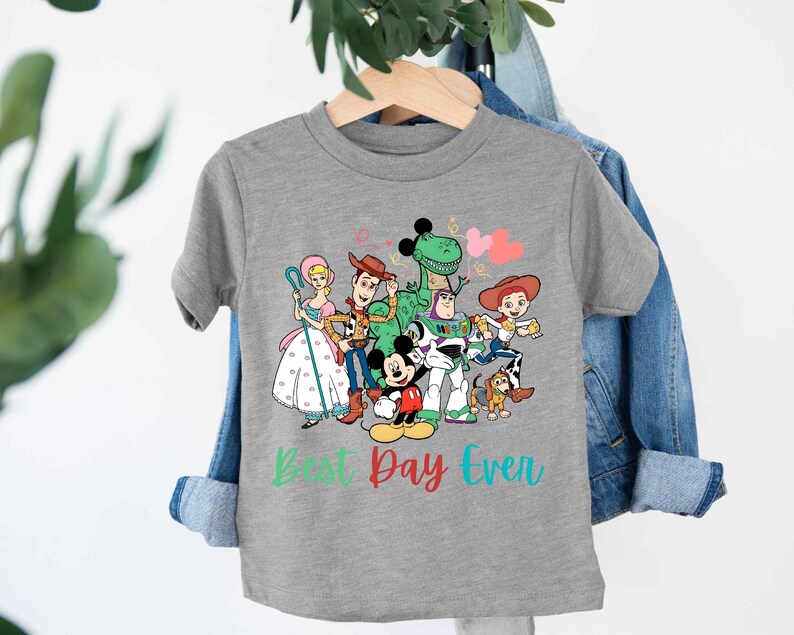 a gray t - shirt with cartoon characters on it