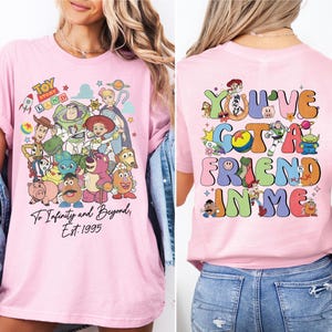 a woman wearing a pink tshirt with cartoon characters on it