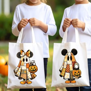 Peut inclure: Deux sacs fourre-tout blancs avec des motifs d'Halloween. Chaque sac présente un personnage de fantôme de dessin animé avec des oreilles de Mickey Mouse, tenant une lanterne citrouille. Les fantômes sont vêtus de tenues patchwork aux couleurs orange, jaune et marron.