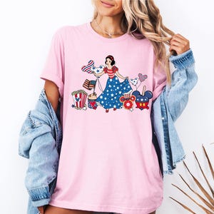 a woman wearing a pink tee shirt with an image of a woman on it