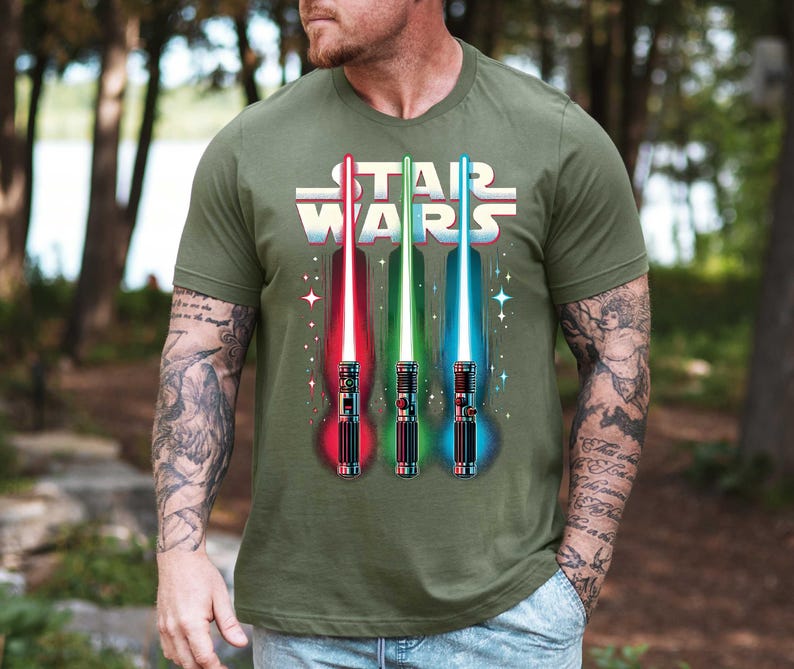 a man wearing a star wars shirt with two lightsabes on it